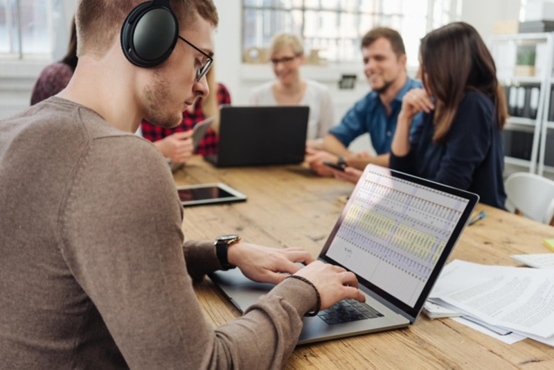 Mann im Büro nutzt ein Headset für Noise Cancelling bei der Arbeit